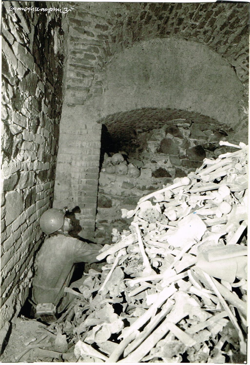 Kostnice - ossárium - pod věží chrámu Panny Marie ve Křtinách v průběhu vyklízení kostí.
Na fotografii Miroslav Sedlák, člen ZO 6-05 Křtinské údolí. Foto: Marek Šenkyřík (1991).
