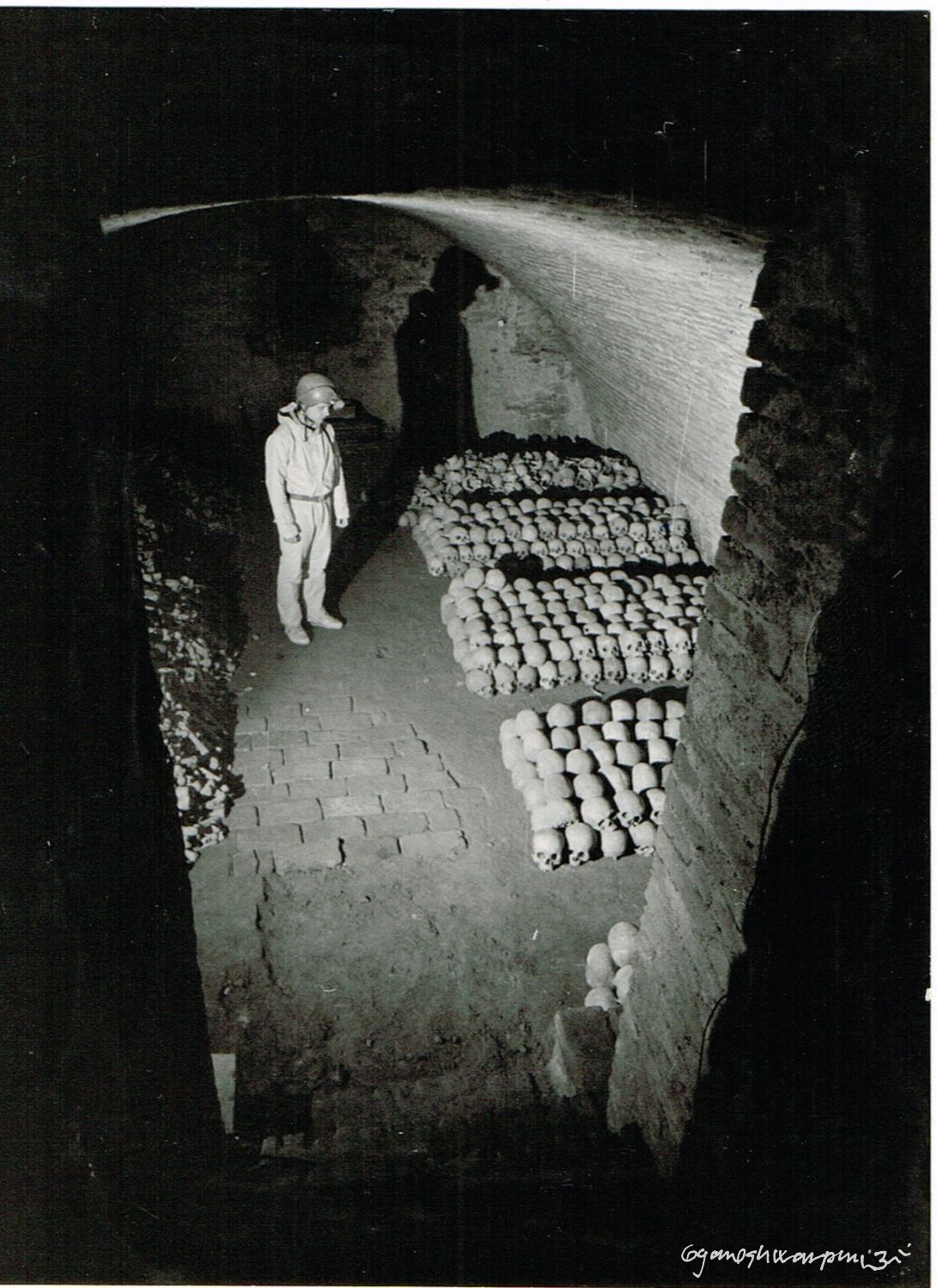 Hlavní krypta chrámu Panny Marie ve Křtinách s přechodně uskladněnými kostmi před transportem na Anatomický ústav LF MU v Brně.
Na fotografii: Radovan Drtil. Foto: Marek Šenkyřík (1991).
