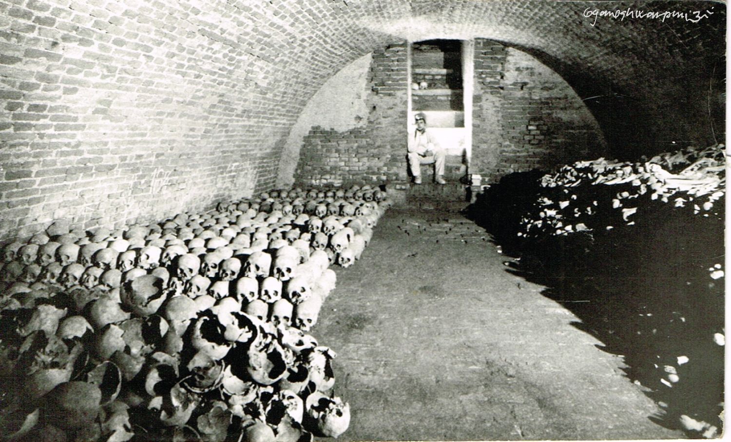 Hlavní krypta chrámu Panny Marie ve Křtinách s přechodně uskladněnými kostmi před transportem na Anatomický ústav LF MU v Brně.
Na fotografii: Radovan Drtil. Foto: Marek Šenkyřík (1991).
