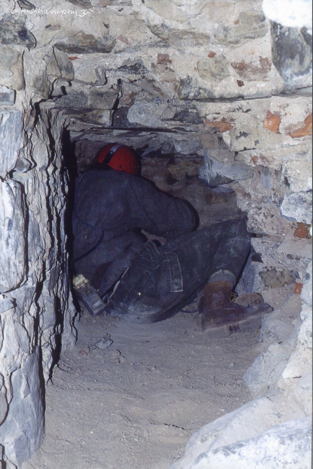 Ražba objevné sondy hutnou zdí do ossária pod věží chrámu Panny Marie ve Křtinách (1991). Foto: Marek Šenkyřík 1991.