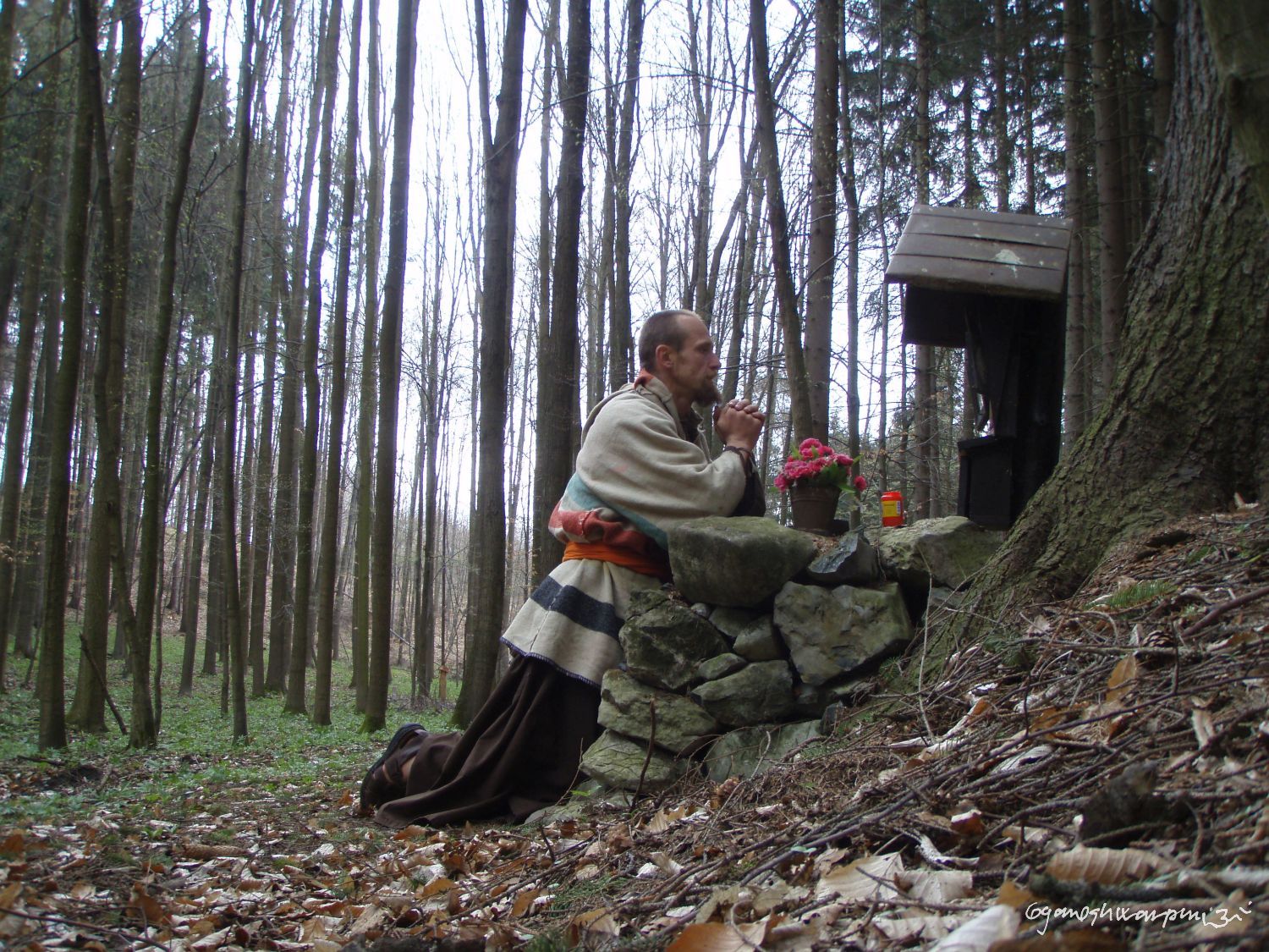 Poustevník Gyaneshwarpuri - pokleknutí u Habrůveckého smnrku na Habrůvecké plošině (Moravský kras - střed) po návratu z Indie.  Foto: Marek Gyaneshwarpuri, samospoušť 2008.