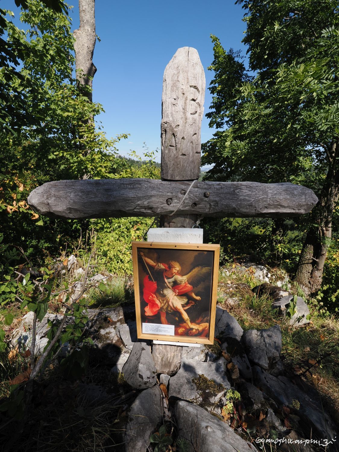 Starý kříž na vrcholu skály Vepřku s mým obrázkem Archanděla Michaela. Foto: Svámí Gyaneshwarpuri (2025).