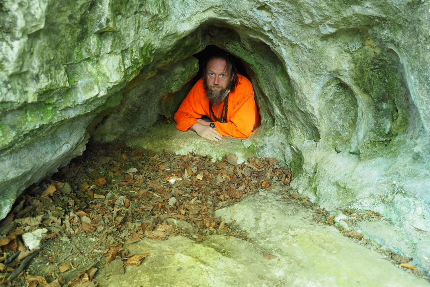 Ve chodu jeskyně Slezákova díra - Záhrobní v místě objevu dětského neolitického hrobu. Na fotografii označeno svíčkou. Foto: Marek Gyaneshwarpuri, samospoušť 2020.